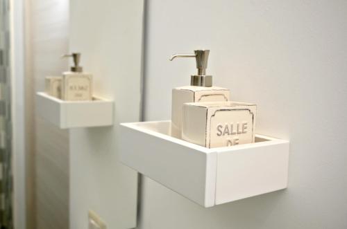 a white soap dispenser on a wall in a bathroom at Mary Lucy in Porto Cesareo