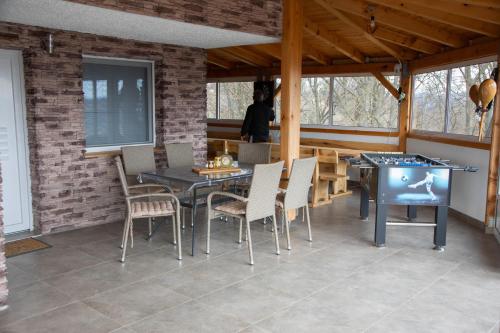 uma sala de jantar com mesa de pingue-pongue e cadeiras em Medeni raj em Mače