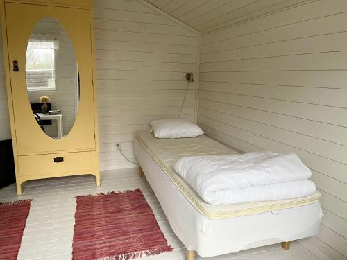 Habitación pequeña con cama y espejo. en Pleasant mobile home located in a scenic location outside Jamjo, en JÃ¤mjÃ¶