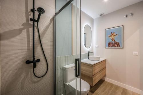 La salle de bains est pourvue d'une douche, de toilettes et d'un lavabo. dans l'établissement Luxe Apartment in Malasaña Hub, à Madrid