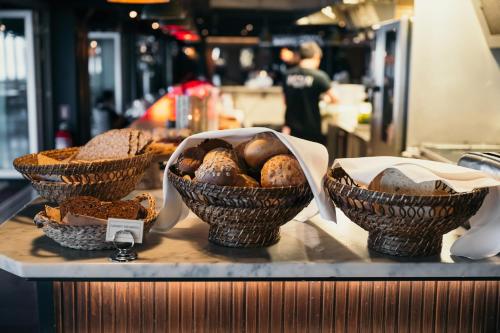 three baskets of bread on a counter in a bakery at Ocean Hotel in Falkenberg