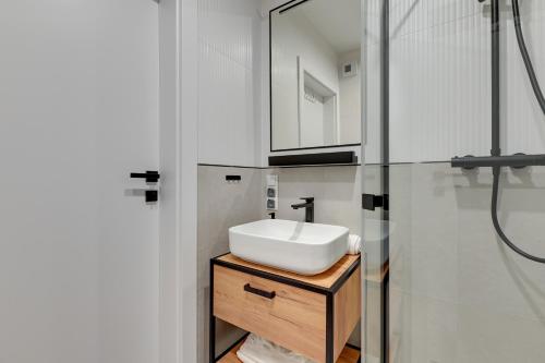 uma casa de banho com um lavatório branco e um chuveiro em Lion Apartments - Młoda Polska Nowy Apartament z parkingiem em Sopot