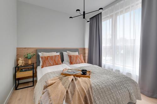 um quarto com uma cama com uma bandeja em Lion Apartments - Młoda Polska Nowy Apartament z parkingiem em Sopot