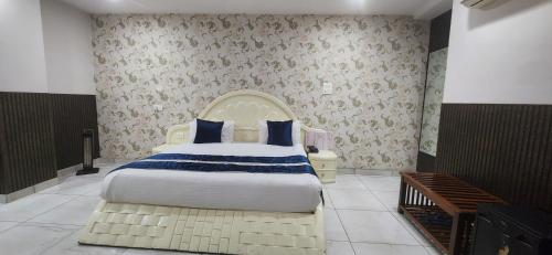 sypialnia z dużym łóżkiem z niebieską i białą pościelą w obiekcie Chopra Residency w mieście Hamīrpur