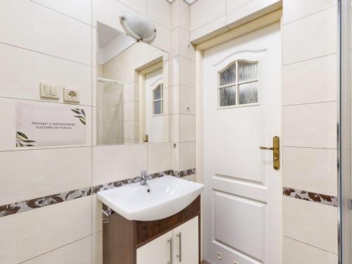 uma casa de banho com um lavatório e um espelho em roomspoznan pl - Pokoje Królowej Jadwigi 44 - 24h self check-in em Poznań