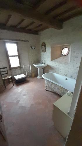 uma grande casa de banho com banheira e lavatório em 6, route de Maisons Manoir d'Argouges em Vaux-sur-Aure