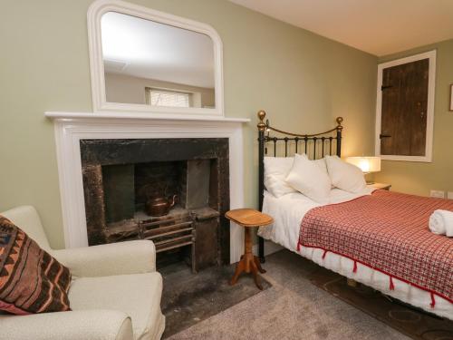 a bedroom with a bed and a fireplace at Printers Cottage in Cockermouth