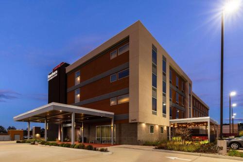 un edificio con un estacionamiento delante de él en Hawthorn Extended Stay by Wyndham Kingwood Houston, en Kingwood