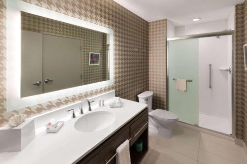 a bathroom with a sink and a toilet and a mirror at Hawthorn Extended Stay by Wyndham Kingwood Houston in Kingwood