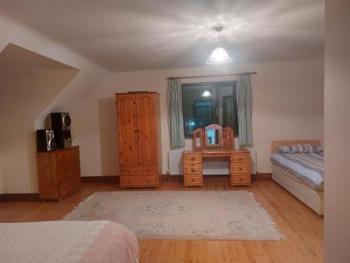 1 dormitorio con 1 cama, vestidor, 1 cama y escritorio en Spacious House in beautiful Malin Head, en Keenagh