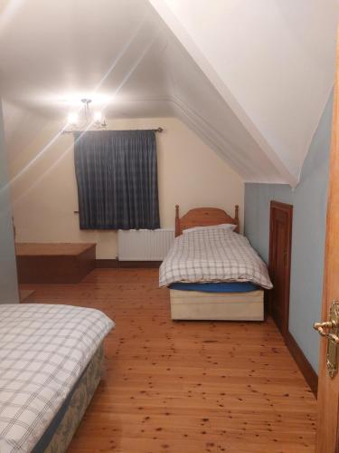 a bedroom with two beds and a window at Spacious House in beautiful Malin Head in Keenagh