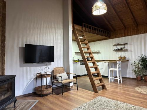a living room with a television and a staircase at Haremi Garden Suit Bungalows in Tokat