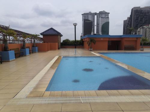 a large swimming pool on the roof of a building at Globallon Services Apartment, Melaka Town Hotel in Melaka