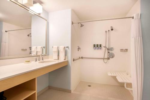 y baño con lavabo y ducha. en Parsippany Suites Hotel, en Parsippany