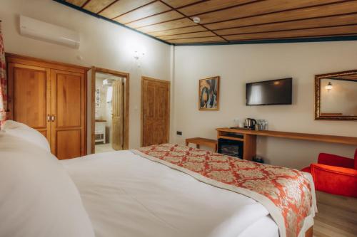 a bedroom with a bed and a tv on the wall at Cappadocia Villa Comfort in Nevsehir