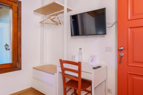 a desk with a chair and a tv on a wall at Bergamo bnb in Villa di Serio