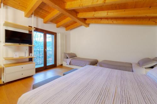 a large room with two beds and a tv at Bergamo bnb in Villa di Serio