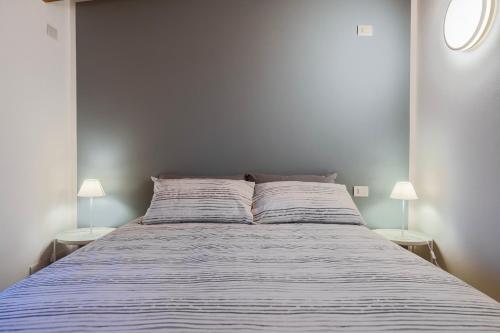 a bedroom with a bed with two lamps on both sides at Bergamo bnb in Villa di Serio
