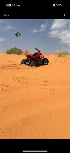 a dirt bike parked in the desert with a flag at غرفة خاصة in Hail