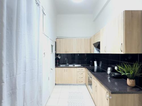 a kitchen with wooden cabinets and a sink at Cozy Home with Yard & Cottage Charm in Athens in Athens