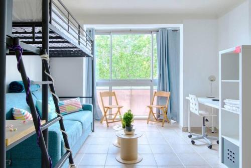 Habitación con sofá azul y litera en BRONZET - T1 à 14 min à pied de la Plage de la Verrerie en Marsella