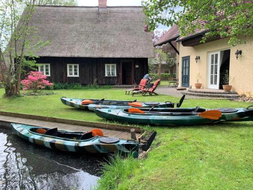 a group of canoes parked in front of a house at Fewo Fischotter in Lehde