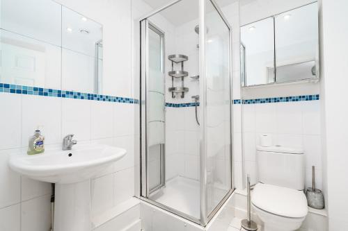a bathroom with a shower and a sink and a toilet at Modern two bedroom two bath opp tube station (central line) in London