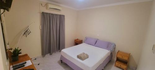 a small bedroom with a bed and a window at OpenSky in São Filipe