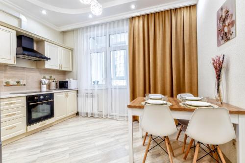 a kitchen with a dining room table and chairs at Апартаменты возле ЭКСПО in Astana