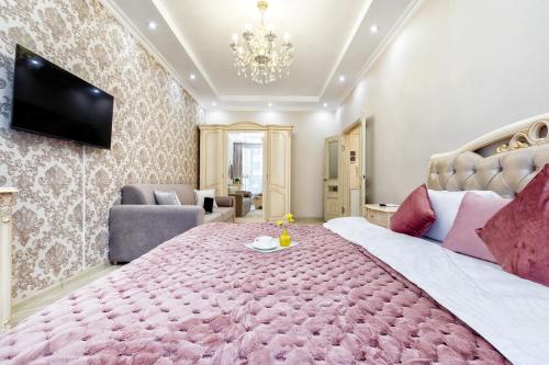 a bedroom with a large bed with a pink blanket at Апартаменты возле ЭКСПО in Astana