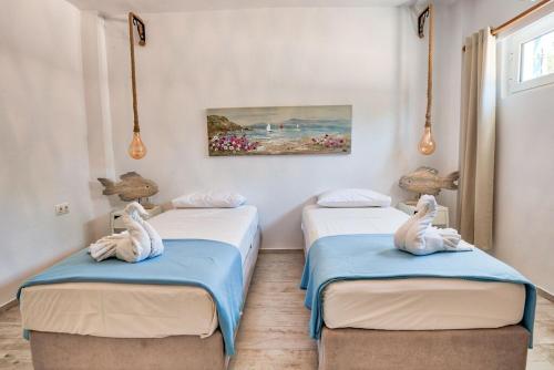 two beds in a room with two swans on them at Villa Iannis in Almyrida slechts 350m van het Strand - Auto huren niet nodig - Gratis Samariakloof in Almirida