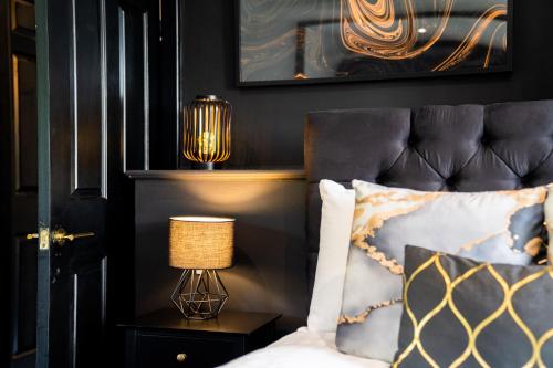 - une chambre avec un lit doté d'une tête de lit noire et d'une lampe dans l'établissement Gorgeous 6 Bed House - Hot Tub - Wifi & Large Garden - Lichfield 40ST, à Shenstone