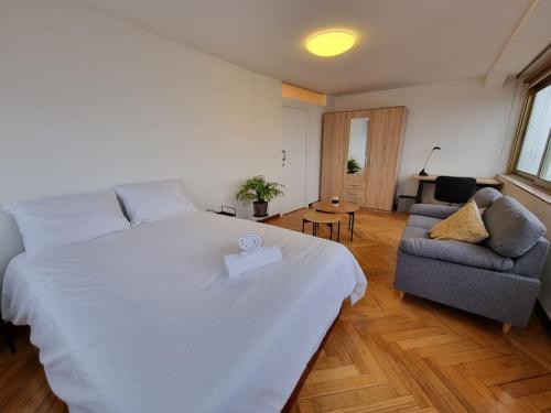 ein Schlafzimmer mit einem großen weißen Bett und einem Sofa in der Unterkunft VibesCoruña- Ponte 2 in A Coruña