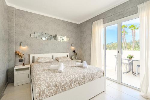 een witte slaapkamer met een bed en een balkon bij Chalet Playa de Las Americas in Arona