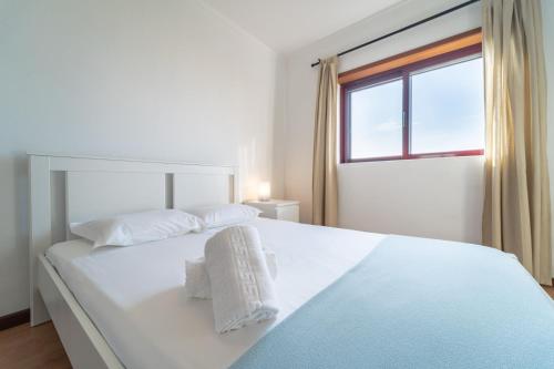 una camera bianca con un grande letto bianco e una finestra di Feliciano Ramos 1 - T4 familiar perto do centro da cidade - Braga a Braga