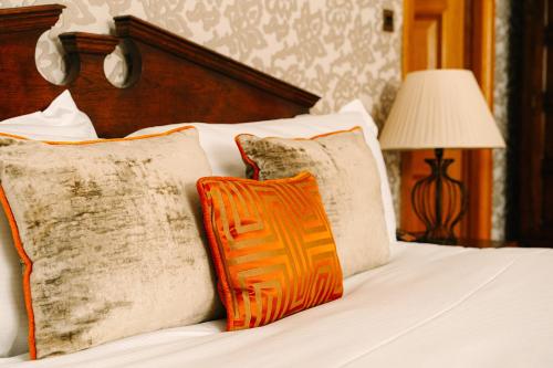 a bed with two pillows and a lamp on it at Lainston House in Winchester