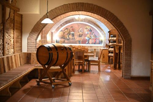 a room with a table and a wine barrel in a store at Mercure Sighisoara Binderbubi Hotel & Spa in Sighişoara