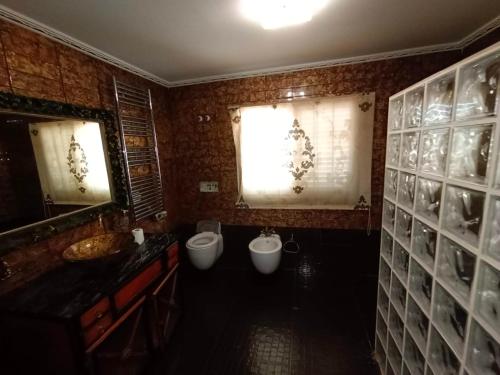 baño con 2 aseos y 2 lavabos y ventana en Villa Esperanza, en La Eliana