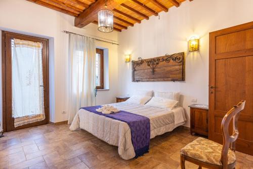 a bedroom with a bed and a chair in it at Agriturismo il Casato Mag-il Giogo in Pienza