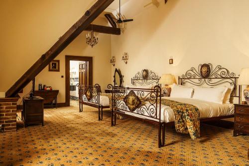 a bedroom with two beds and a staircase at Lainston House in Winchester