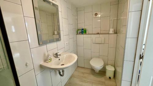 uma casa de banho branca com um lavatório e um WC em MEDDAYS VILLA PARIS 53 em Miami Platja
