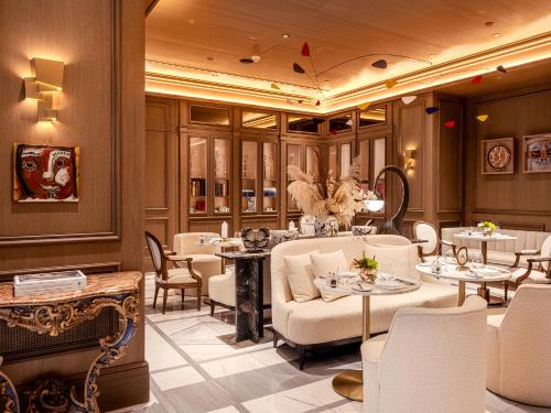 a restaurant with white furniture and tables and chairs at The Dolli at Acropolis, A Hotel to Live in Athens