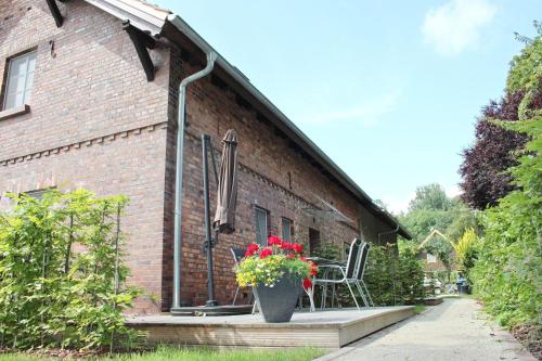 a porch of a brick house with a vase of flowers at Hopkas Scheune in Lehde