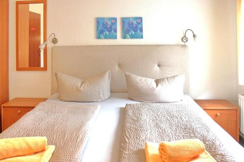 a bedroom with a white bed with two pillows at Pension An der Kamske DZ 1 in Lübbenau