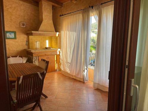 ein Esszimmer mit einem Tisch und einem Fenster in der Unterkunft Casa Ada romantico appartamento in Chia