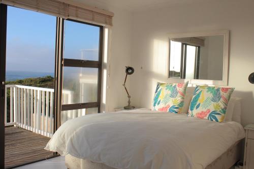 スティル・ベイにあるPlankeplekkieのベッドルーム1室(ベッド1台付)、景色を望むバルコニーが備わります。