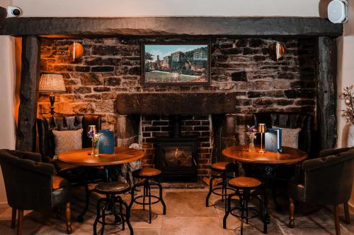 a room with two tables and a fireplace at The Ashford Arms in Bakewell