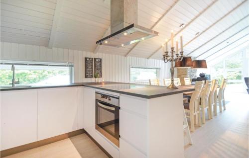 a kitchen with white cabinets and a stove top oven at Four-Bedroom Holiday Home In Spottrup in Spottrup