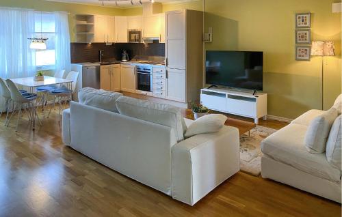 a living room with a white couch and a tv at Amazing Apartment In Färjestaden in Färjestaden