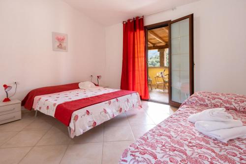 a bedroom with two beds and a sliding glass door at Angel Village in San Teodoro